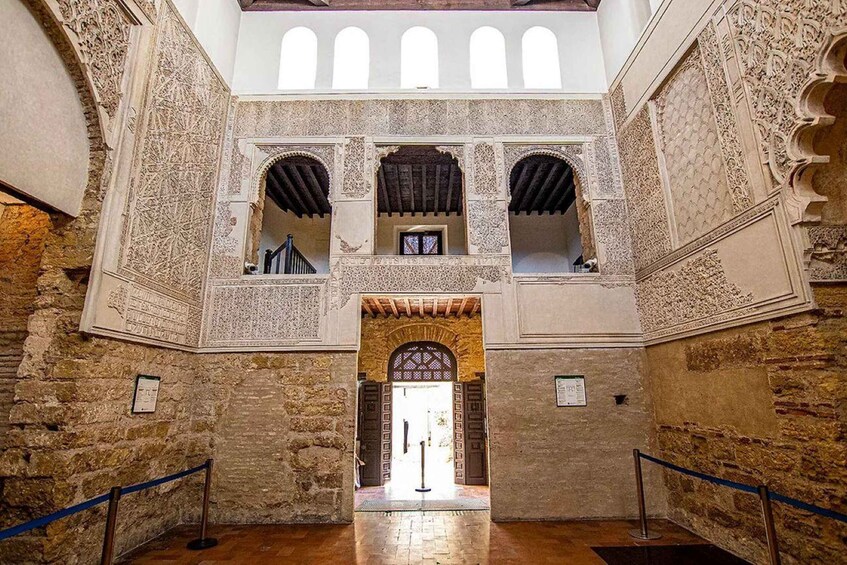 An interior with ornate arches and detailed stonework. 2