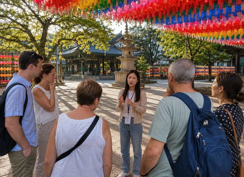 A group of tourists at a temple with traditional architecture and colorful hanging decorations. 1