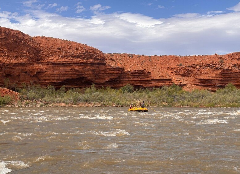 A river with a raft, surrounded by red rock formations. 2