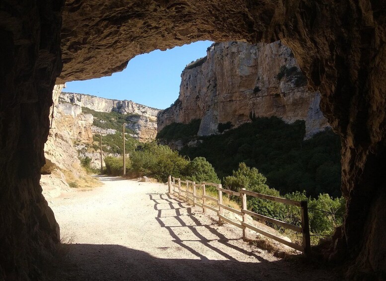 A rocky cave entrance with a dirt path leading outside. 2