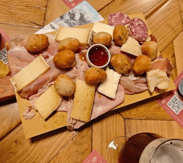 A charcuterie board with various cheeses, meats, and bread on a wooden table. 4