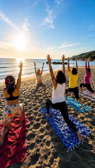 A group of people doing yoga on a beach with the ocean and sunset in the background. 1