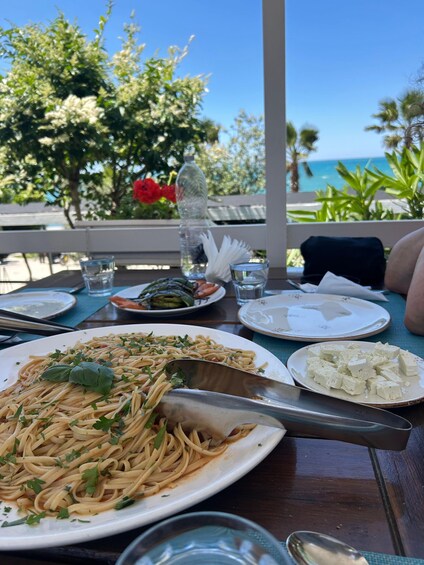 A table with a plate of pasta, a glass of water, and a bottle of water. 2