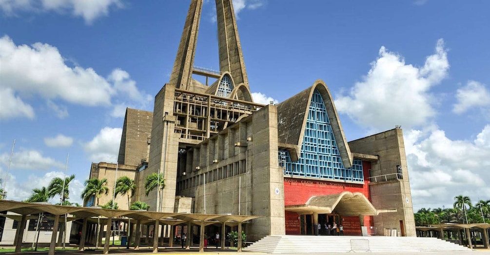 A large, modern building with a prominent triangular roof and two tall towers. 5