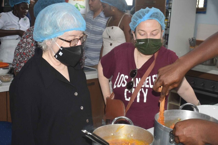 People wearing hairnets and masks, preparing food in a kitchen. 4