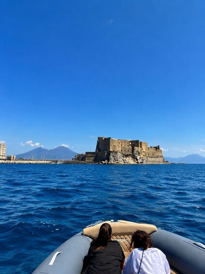 A boat with two people, a coastal cityscape, and a prominent castle on a cliff. 4