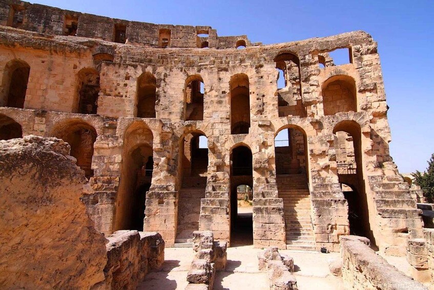 Ancient ruins with multiple arched doorways and a large open space. 3