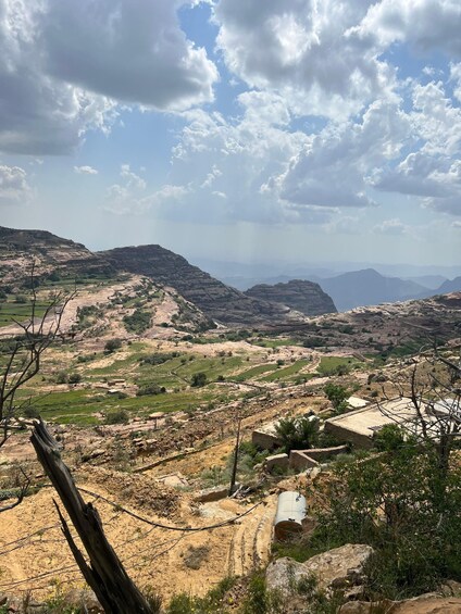 A mountainous landscape with terraced fields and scattered buildings. 3
