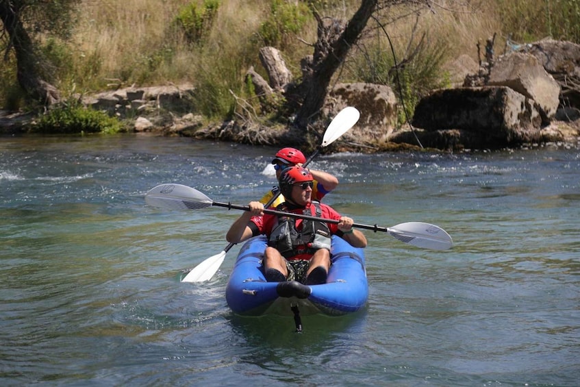 A person kayaking on a river. 3