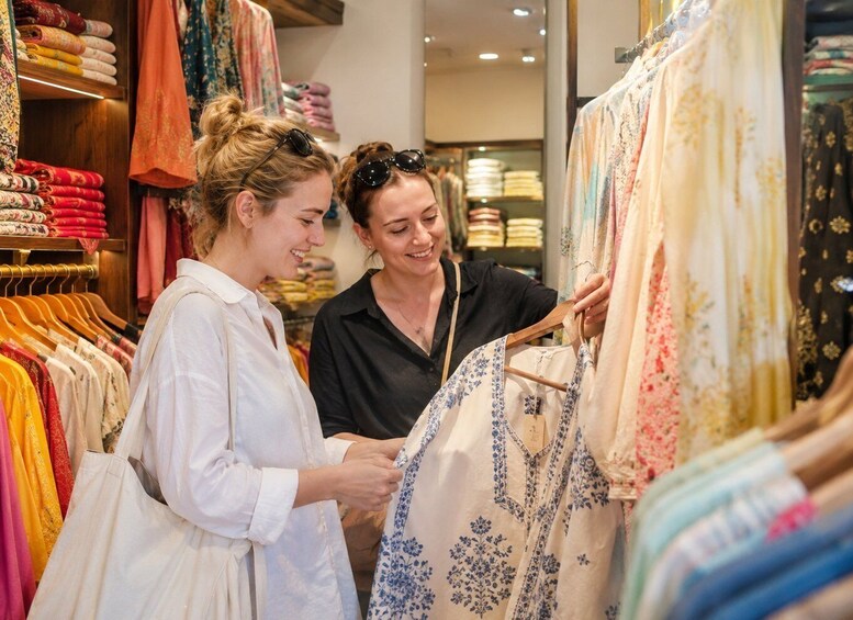 Two people examining a dress in a clothing store. 2