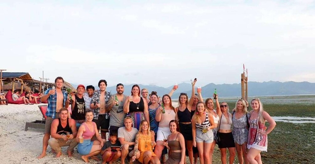 A group of people on a beach with mountains in the background. 5