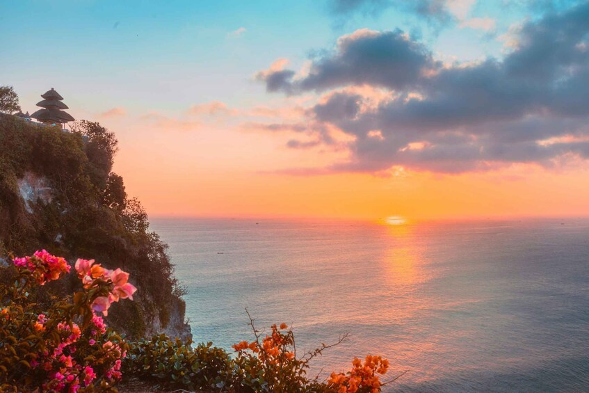 A sunset over the ocean with a traditional pagoda on a cliff. 3