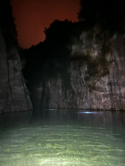 A cave with a water body reflecting light. 4