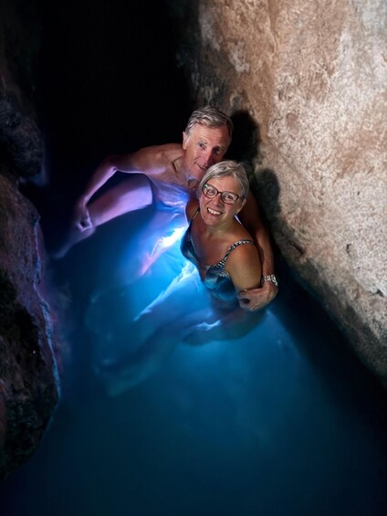 Two people in a cave with blue lighting. 1