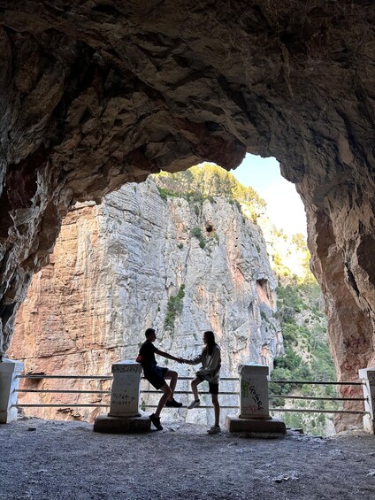 Two people dancing in a cave with a rocky backdrop. 2