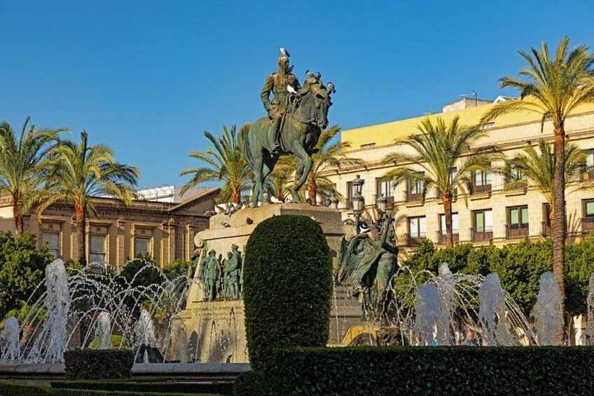 A statue of a figure on horseback, a fountain, and a building with balconies. 2