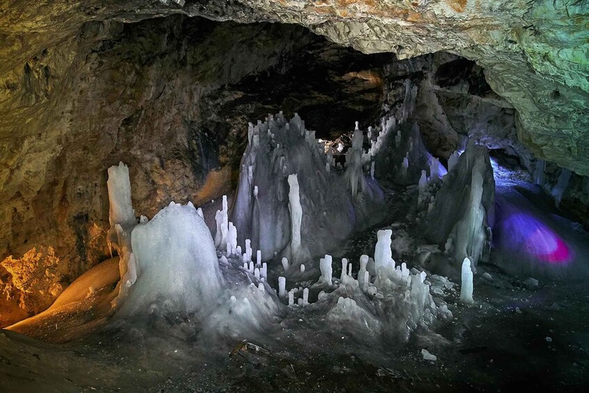 A cave with ice formations and a purple light. 3