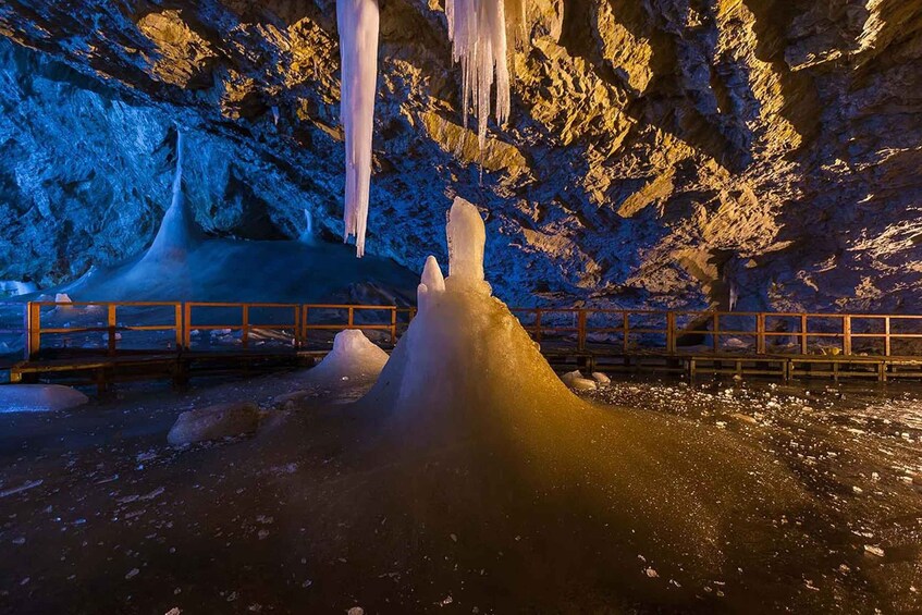 A cave with ice formations and a wooden walkway. 1