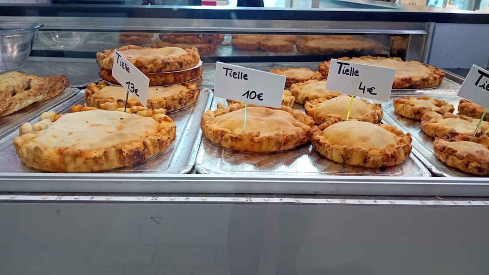 A display of pies with price tags in a bakery. 4