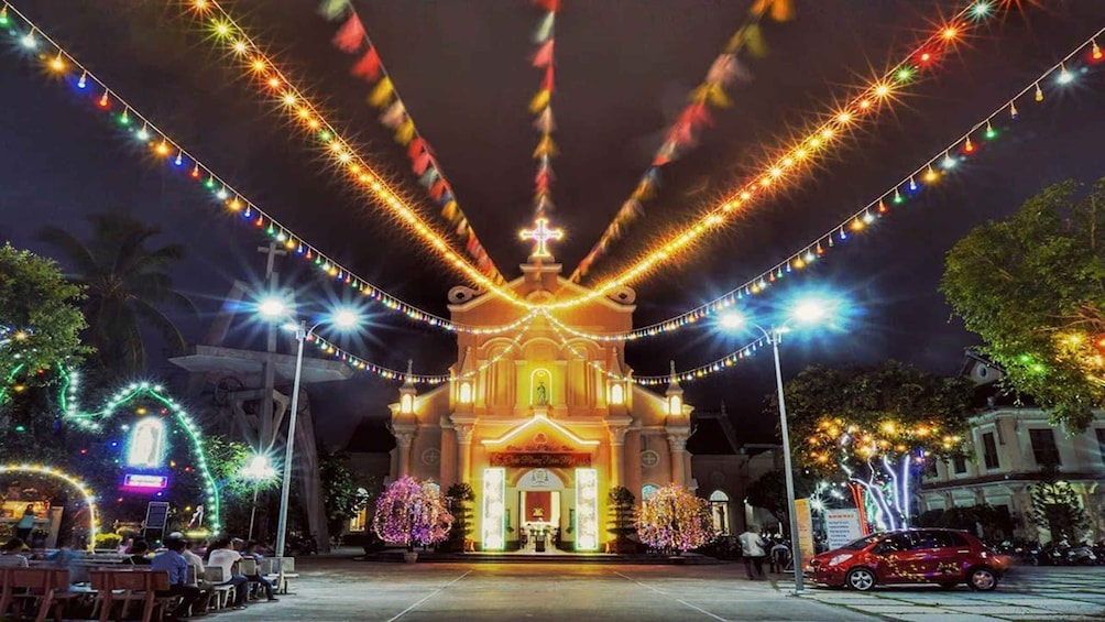 A church illuminated with colorful lights and surrounded by trees. 2