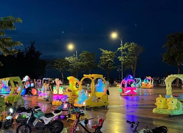 A nighttime amusement park with brightly lit rides and a clear sky. 5