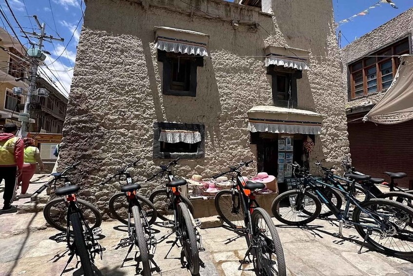 A stone building with multiple bicycles parked in front. 2