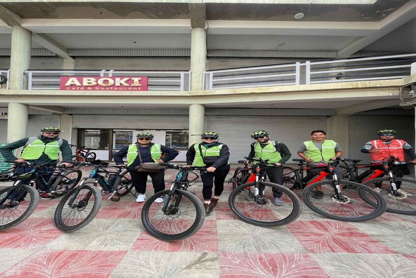 A group of cyclists in front of a building with a sign that reads 'ABOKI Cafe & Restaurant.' 3