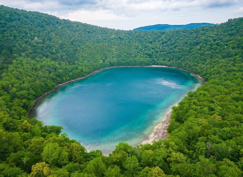 A turquoise lake surrounded by dense forest. 1