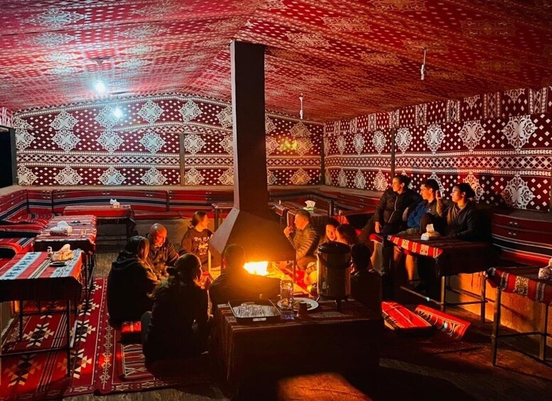 A traditional restaurant with patterned walls and a central fire. 4