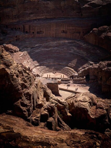 An ancient amphitheater carved into a cliffside. 3