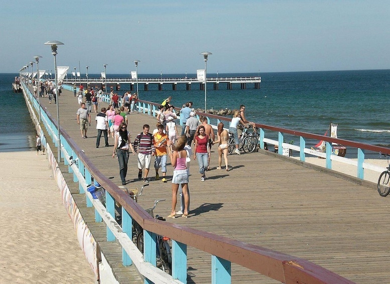 A pier with people walking and bicycles parked. 2