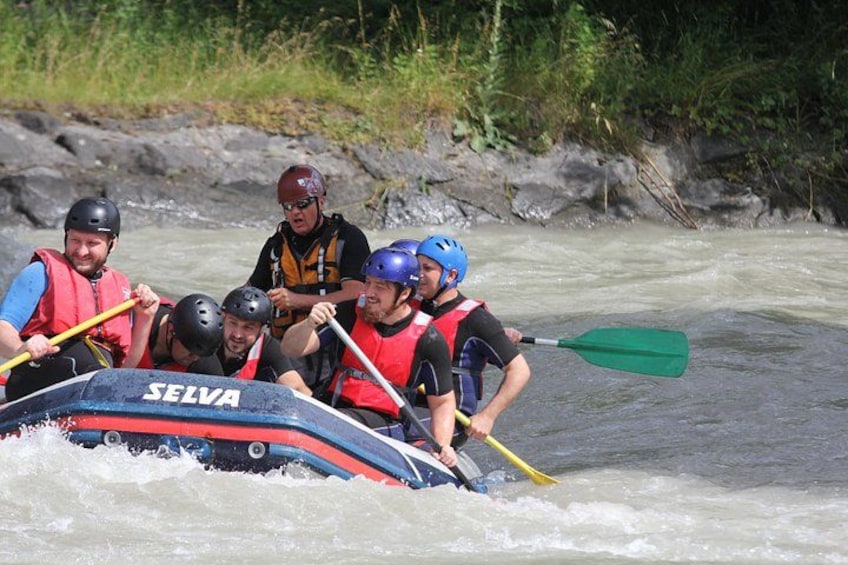 A group of people in a raft navigating a river. 1