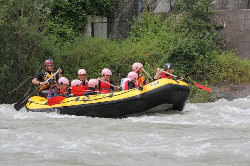 A group of people in a yellow raft navigating a river. 5