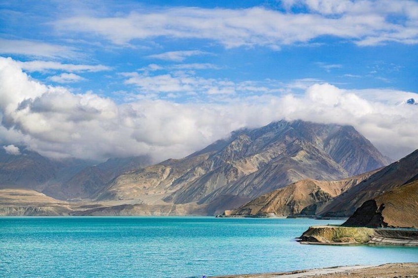 A mountain range, a turquoise lake, and a rocky shoreline. 3