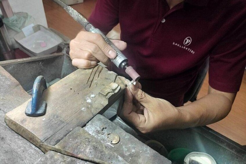 A person using a power tool on a wooden workbench. 2