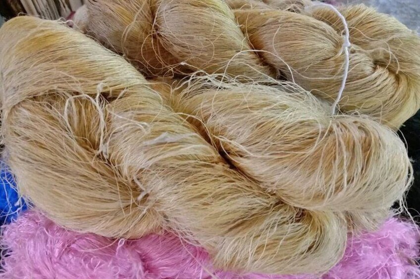 A collection of blonde yarn balls on a pink fluffy surface. 5