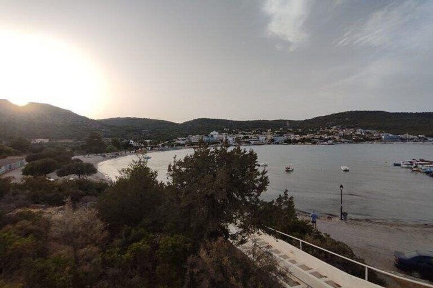 A coastal town with boats, a beach, and hills in the background. 3