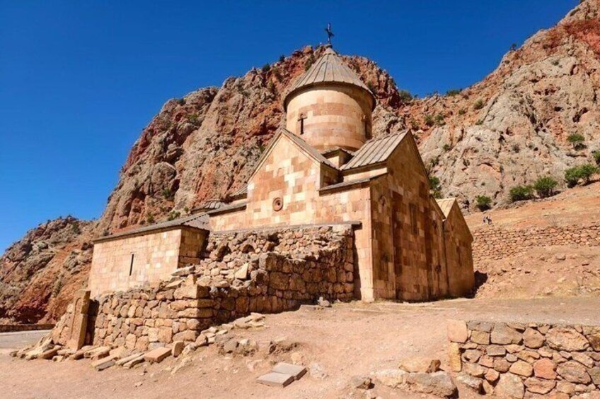 A stone chapel with a dome, surrounded by rocky terrain. 3