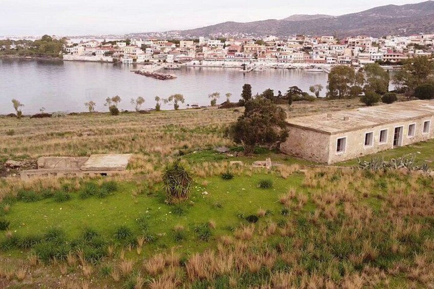 A coastal town with a large body of water, a grassy field, and a building with a flat roof. 4