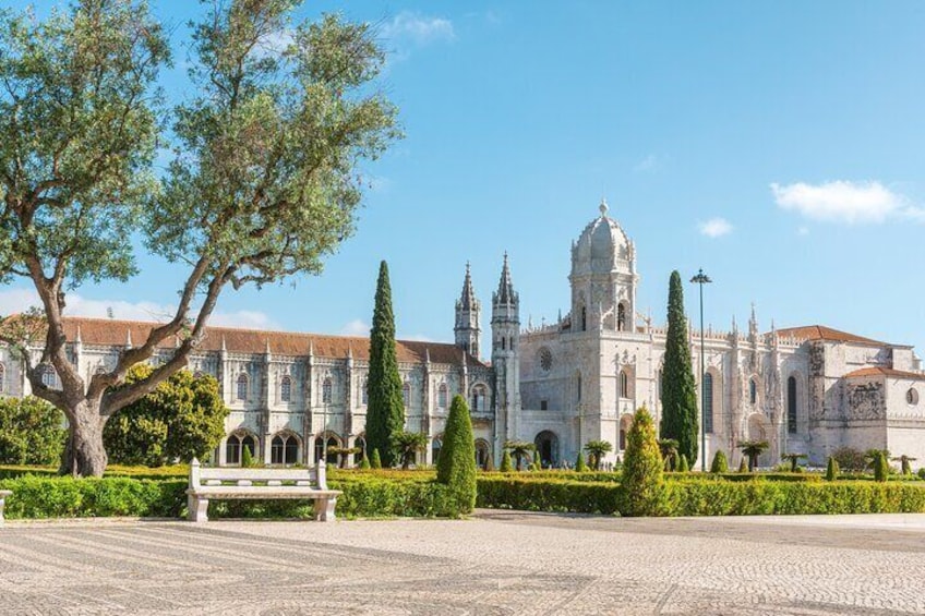 A historic building with a dome, surrounded by a well-maintained garden and a paved area. 5