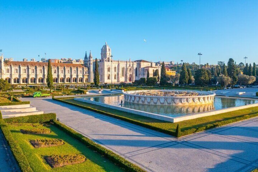 A large, historic building with a dome, a fountain, and a well-maintained garden. 4