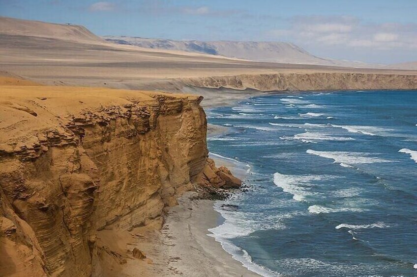A coastal cliff with waves crashing against it. 4