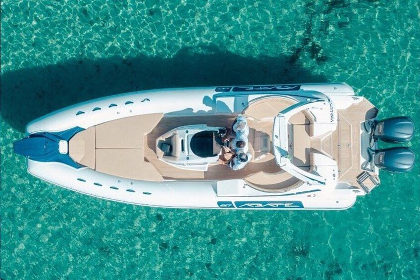 A white boat with a cabin and two outboard motors on turquoise water. 1