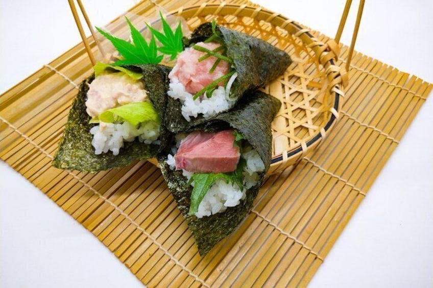 Sushi rolls with rice, fish, and vegetables on a bamboo mat. 3