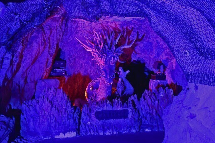A cave with stalactites and stalagmites, illuminated by blue lighting. 2