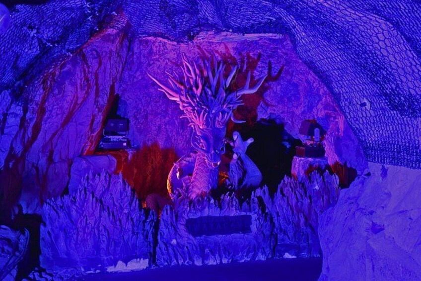 A cave with stalactites and stalagmites, illuminated by blue lighting. 2
