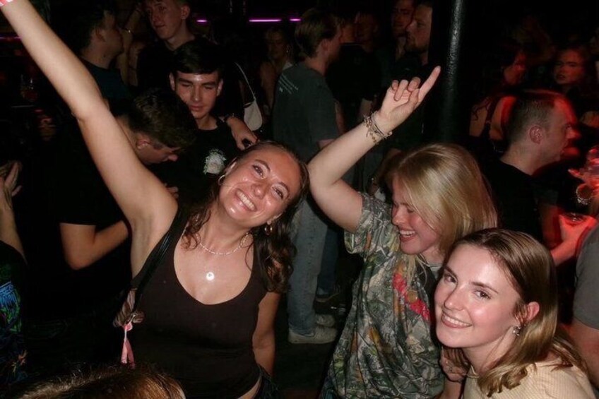 A crowded indoor event with people standing and interacting. 1