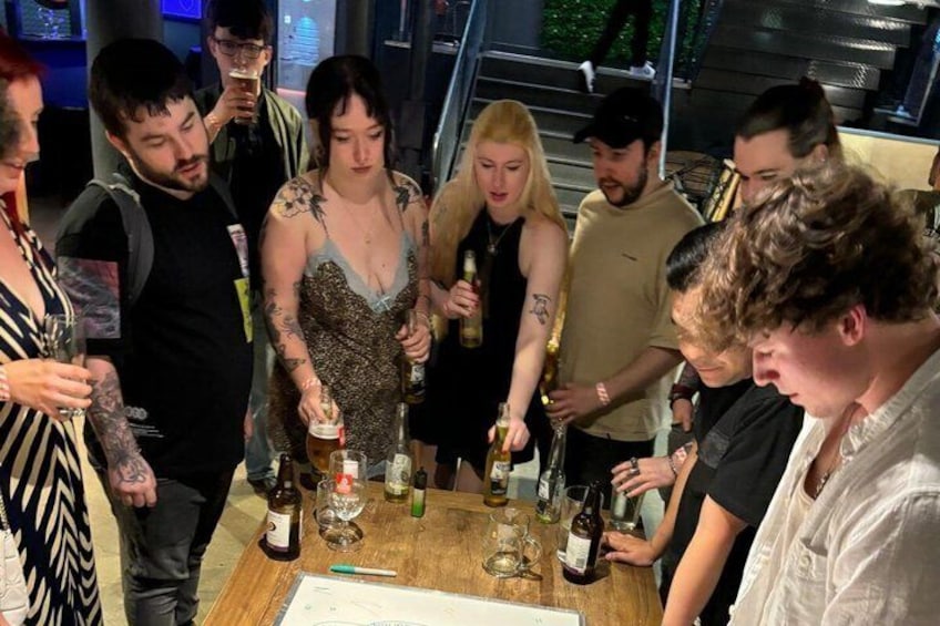A group of people around a table with bottles and glasses, possibly at a social gathering. 5