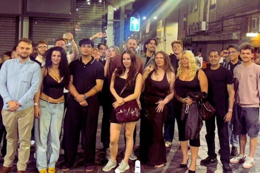 A group of people standing on a city street at night. 5