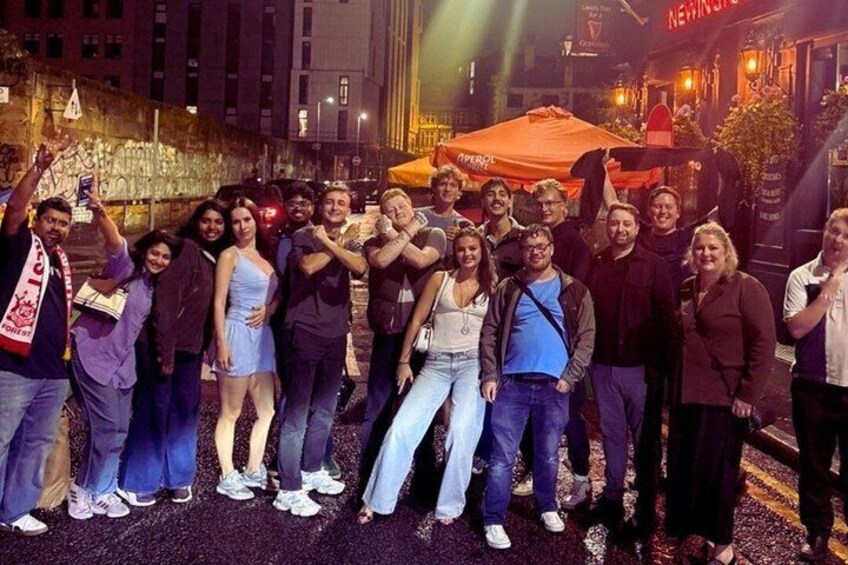 A group of people posing for a photo in an urban setting at night. 4